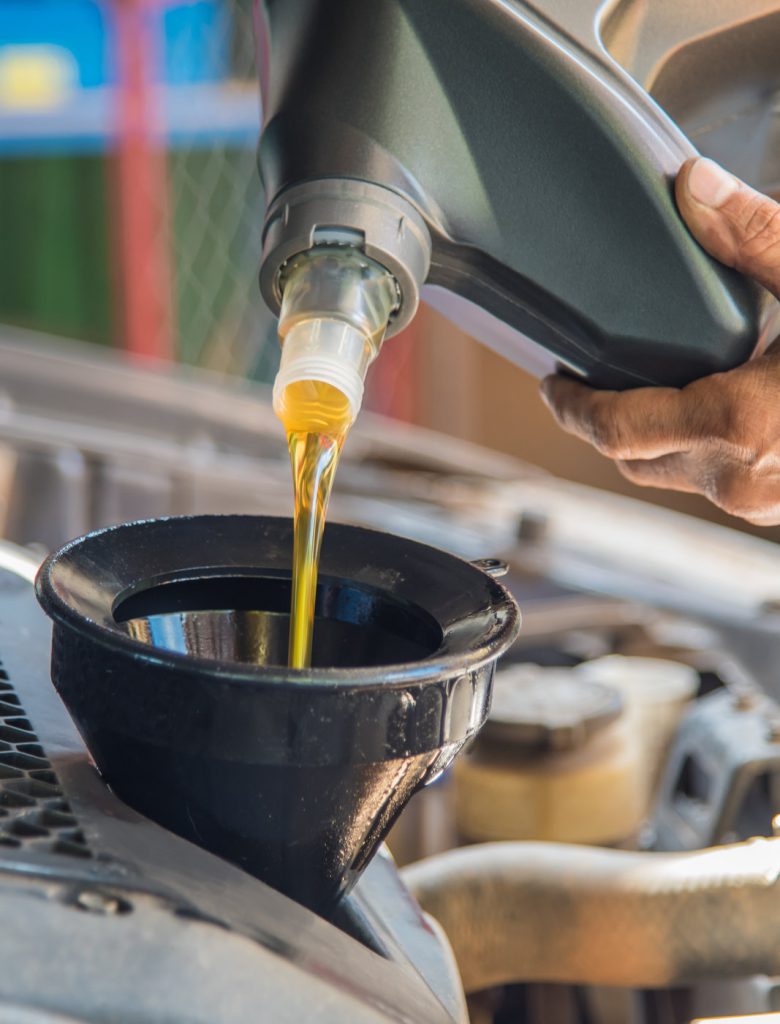 Mechanic pouring engine oil into a vehicle - Car Servicing Oxford